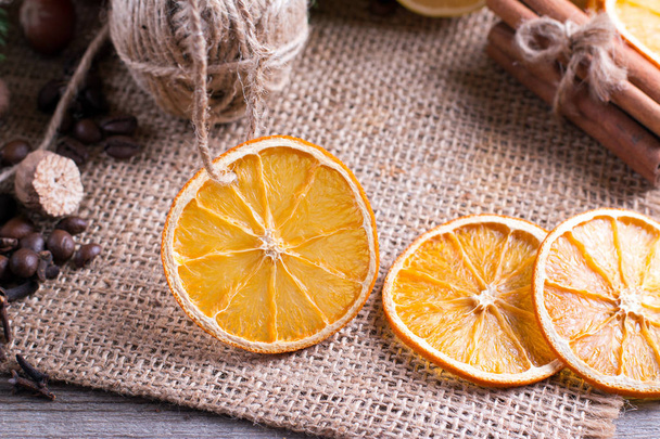 Suszonych orange na podłoże drewniane. Pierścienie z suszonych owoców cytrusowych na stole. - Zdjęcie, obraz