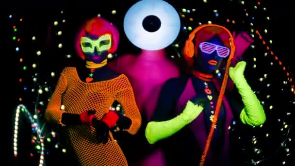 Szexi nők és férfi rekord vinil fejét a fekete Uv-fényben fluoreszkáló ruházat. - Felvétel, videó