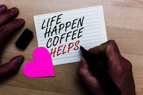 Handgeschreven tekst schrijven leven gebeuren koffie helpt. Concept, wat betekent dat een warme drank te nemen wanneer problemen problemen geschreven op Kladblok hand houden marker met houten achtergrond van het hart van liefde - Foto, afbeelding