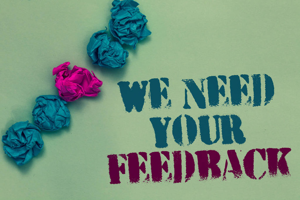 Writing note showing We Need Your Feedback. Business photo showcasing Give us your review thoughts comments what to improve Drawn blue and red words teal color paper lump mid pink on blue floor - Photo, Image