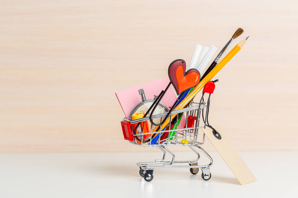 Stationery items in shopping trolley at left side - Foto, Bild