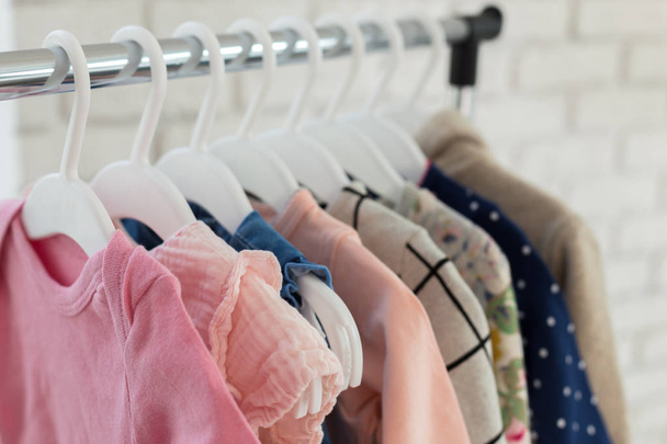 Colorful children clothes hanging on hangers - 写真・画像