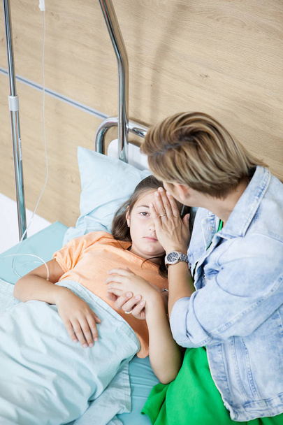 Mother taking care of her daughter in hospital room - Foto, afbeelding