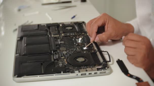 男がノートパソコンを修理している。コンピュータの修理の概念。ドライバで人の修理ノートパソコンのマザーボードを閉じます。マザーボードのハードウェアのメンテナンス。ディスクホルダー、コンピュータの修理 - 映像、動画