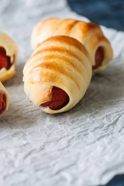 Pigs in a blanket on a baking paper. Close up. Fast food, beer snack or lunch box food concept. - Фото, зображення