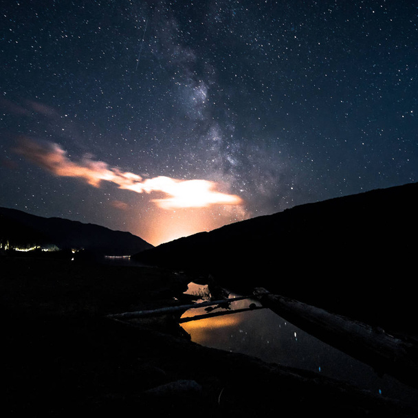 Milky Way galaxy night sky over small pond with reflection. Canada, British Columbia. - Fotoğraf, Görsel
