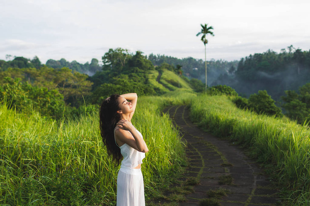 Fiatal nő élvezi időt, és pózol a Campuhan Ridge módja a művészek, Ubud, Bali. - Fotó, kép
