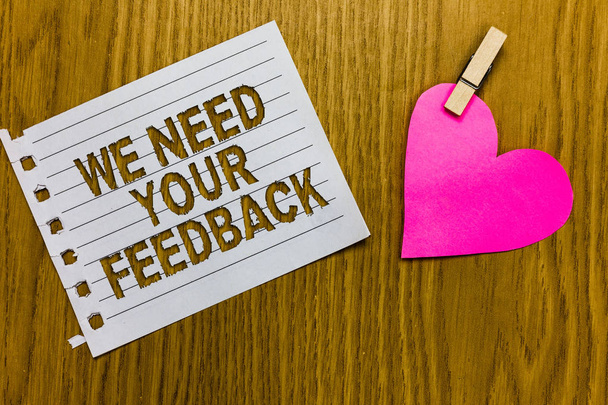 Conceptual hand writing showing We Need Your Feedback. Business photo showcasing Give us your review thoughts comments what to improve Yellow woody deck word with white page paper clip grip heart - Photo, Image