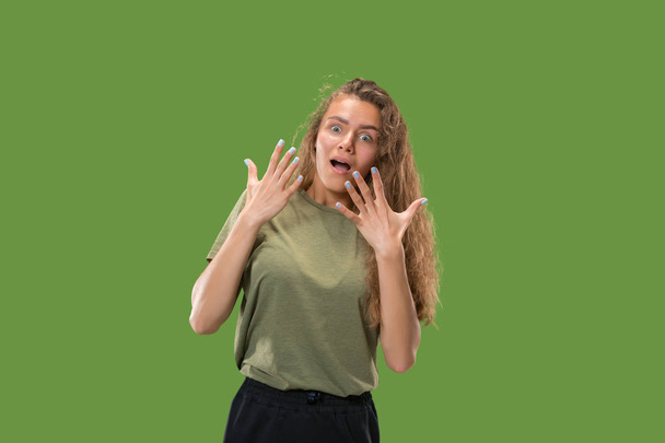 Beautiful woman looking suprised isolated on green - Φωτογραφία, εικόνα