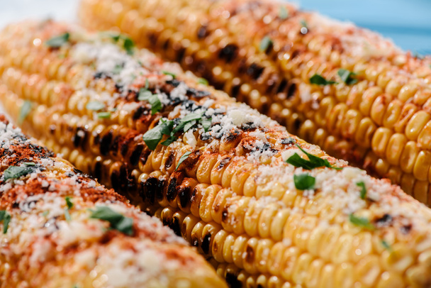 Selektywny fokus pyszne kukurydza z grilla z przyprawa chili, pietruszką i solą  - Zdjęcie, obraz