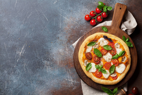 Pizza italiana com tomate, mussarela e manjericão. Vista superior com espaço para o seu texto
 - Foto, Imagem