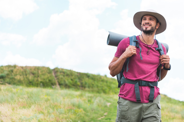 Glücklicher Wanderer mit Rucksack auf grüner Wiese - Foto, Bild