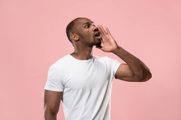 Isolated on pink young casual man shouting at studio - Photo, Image