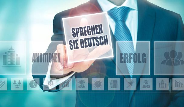 Ένας επιχειρηματίας πιέζοντας ένα κάνει σας μιλούν γερμανικά «Sprechen Sie Deutsch» κουμπί στα Γερμανικά σε μια οθόνη υπολογιστή φουτουριστικό - Φωτογραφία, εικόνα