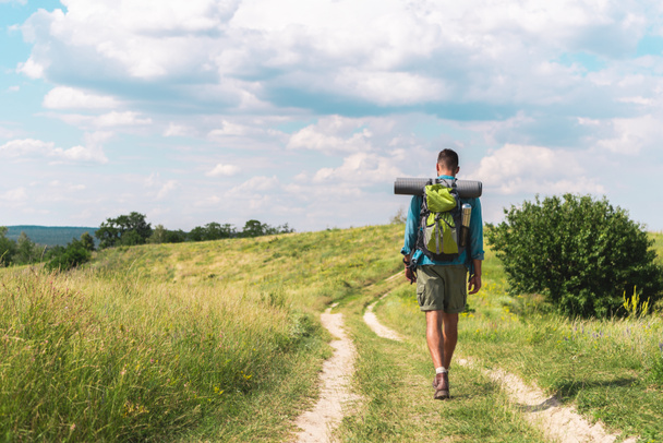 Uzun yürüyüşe çıkan kimse yeşil çayır yolda yürüyen sırt çantası ile Dikiz - Fotoğraf, Görsel
