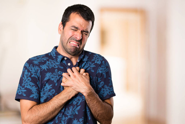 Брюнетка мужчина с болью в сердце в комнате
 - Фото, изображение