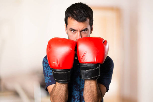Brunette man with boxing gloves inside room - Photo, Image
