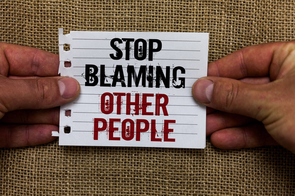 Text sign showing Stop Blaming Other People. Conceptual photo Do not make excuses assume your faults guilt Man holding piece notebook paper jute background Communicating ideas - Photo, Image