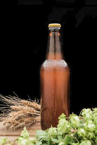 бутылка пива с хмелем и пшеницей и стакан
 - Фото, изображение