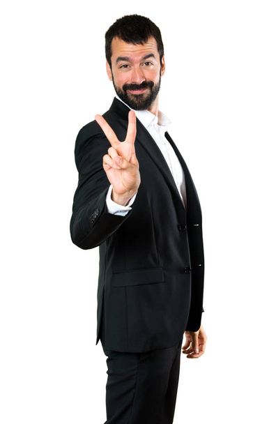 Handsome businessman making victory gesture - Foto, Imagem