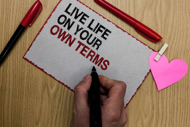Текстовый знак, показывающий Live Life On Your Own Terms. Концептуальное фото Дайте себе рекомендации для хорошей жизни Письменные липкие записки клип щепотка сердца рука держать маркер красная ручка на деревянный стол
 - Фото, изображение