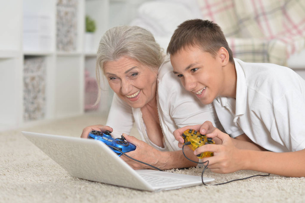 祖母と孫のラップトップ コンピューター ゲームの肖像画  - 写真・画像
