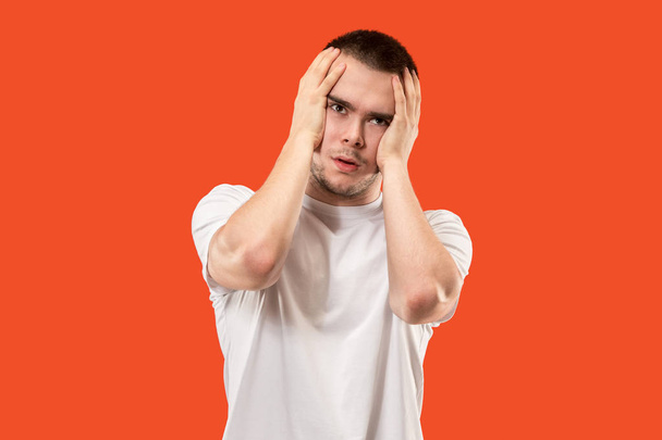 Man having headache. Isolated on pink background. Business man standing with pain isolated on trendy orange studio background. Male half-length portrait. Human emotions, facial expression concept - Foto, Imagen