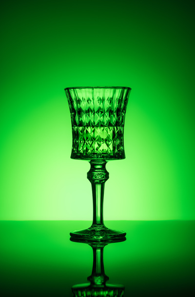 crystal glass of absinthe on reflective surface and dark green background - Photo, Image