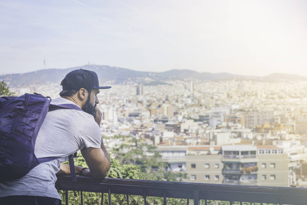 Traveler man looking on a big city, travel and active lifestyle concept.Bearded Tourist Man with backpack enjoy beautiful city view. - Foto, Bild