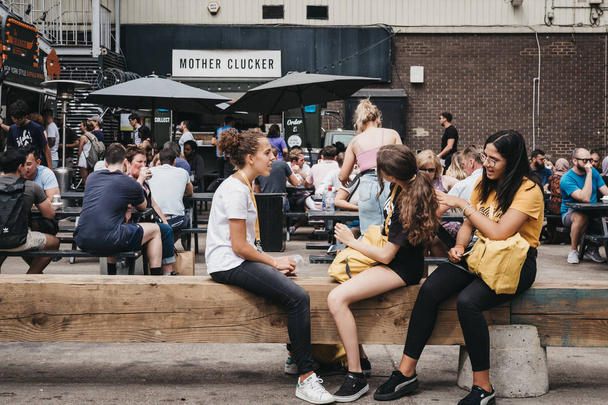 London, UK - July 22, 2018: People enjoying street food in Ely's Yard, a popular industrial-style street food market just off Brick Lane, East London. - Valokuva, kuva