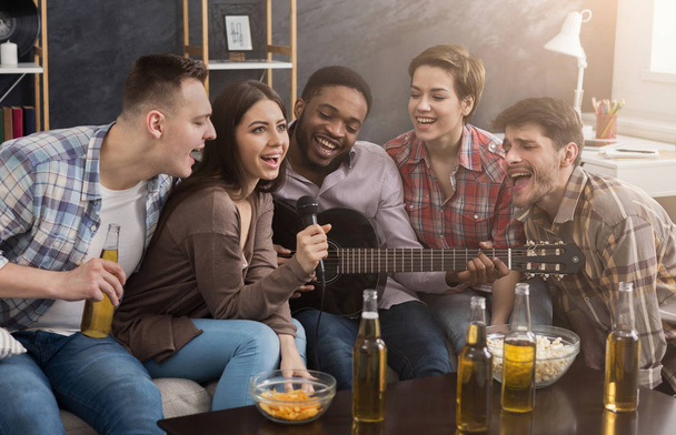 Amigos disfrutando cantando y tocando guitarra
 - Foto, Imagen