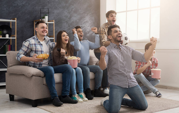Szczęśliwy przyjaciółmi oglądania meczu piłki nożnej w domu - Zdjęcie, obraz