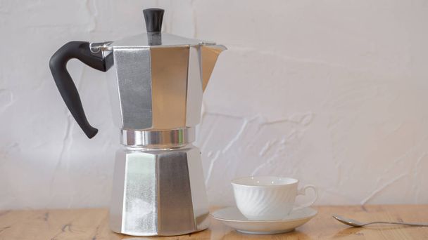 silver coffee moka pot and cup on wooden table. - Foto, Imagen