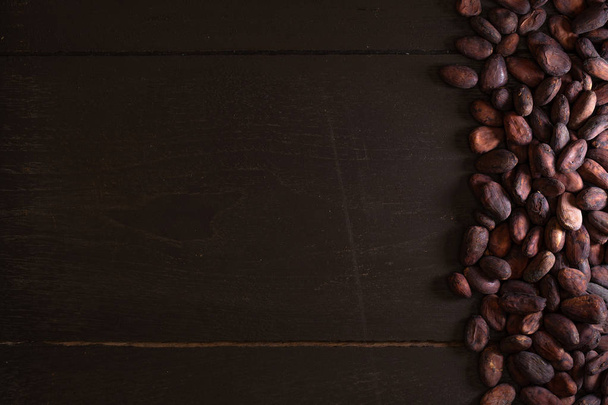 Сухие бобы какао на темном деревянном фоне
 - Фото, изображение