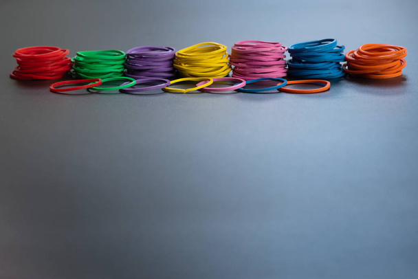 Teamwork concept. group of colorful rubber band on black background with copy space - Photo, image