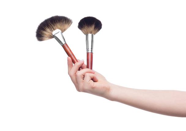 Косметические щетки для макияжа в женской руке
 - Фото, изображение