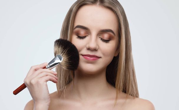 Portrait of attractive young woman holding brush - Photo, Image