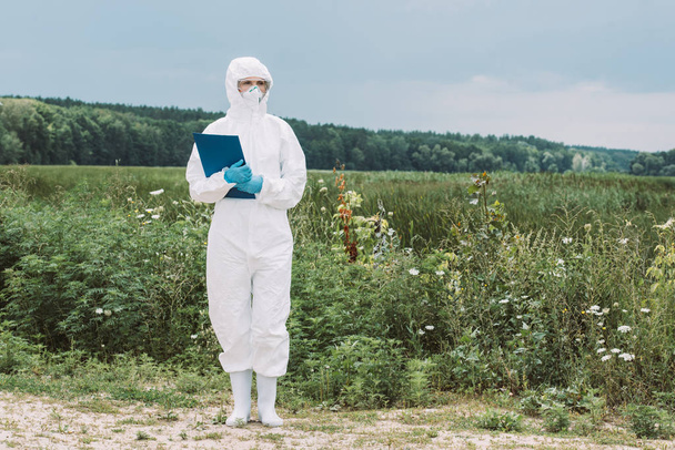 női tudós védőöltözet és googles vágólapon lévő rét  - Fotó, kép