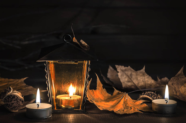 velas, linterna vieja, hojas de otoño sobre una mesa de madera
 - Foto, imagen