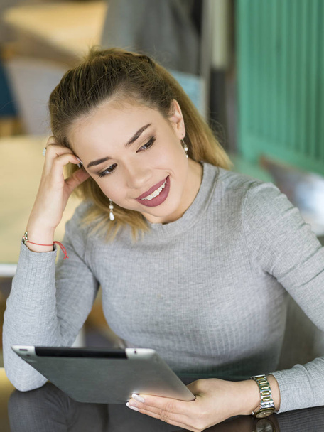 Sorrindo jovem mulher usando um tablet digital mãos de perto - Foto, Imagem