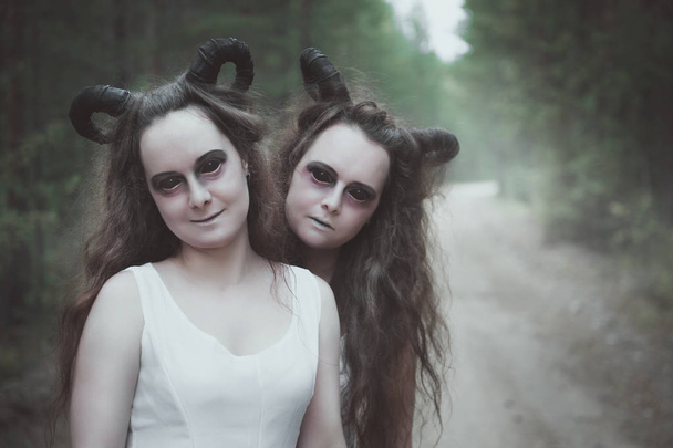 屋外の森で角を持つ悪魔の双子 2 - 写真・画像