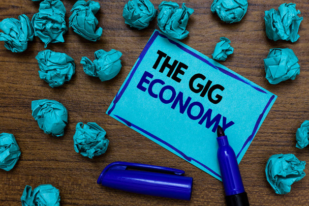 Εννοιολογική χέρι γραφή δείχνει το Gig οικονομία. Επαγγελματίες φωτογραφία παρουσιάζοντας αγορά της βραχυπρόθεσμης συμβόλαια freelance εργασία προσωρινή γραπτή μπλε γράμματα σελίδα μπλε δείκτης και εξογκώματα χαρτί - Φωτογραφία, εικόνα