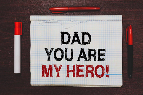 Handschrift Text schreiben Papa, du bist mein Held. Konzept bedeutet Bewunderung für deinen Vater Liebesgefühle Kompliment geschrieben schwarz, rote Wörter Notizblock auf brauner Bühne weiße Textmarker rote Stifte - Foto, Bild