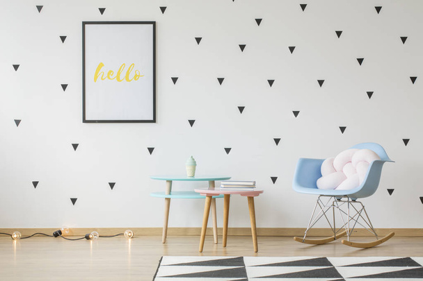 Poster mockup on the wall with triangles wallpaper in bright kid's room interior with pastel furniture and a knot cushion on a rocking chair. Real photo - Zdjęcie, obraz