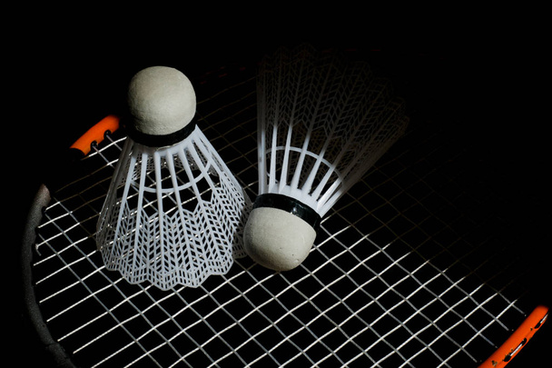 Badmintonové míčky a raketa izolované na černém pozadí, noc. - Fotografie, Obrázek