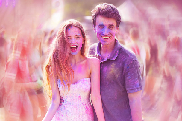Holi Festival Of Colours. Portrait of pretty young couple on holi color festival. Girl and boy with colorful long pink and blue hair. Colorful powder paint on face. Color festival background. Friends. - 写真・画像