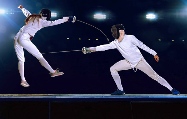 Two fencing athletes fight on professional sports arena - Foto, Imagen