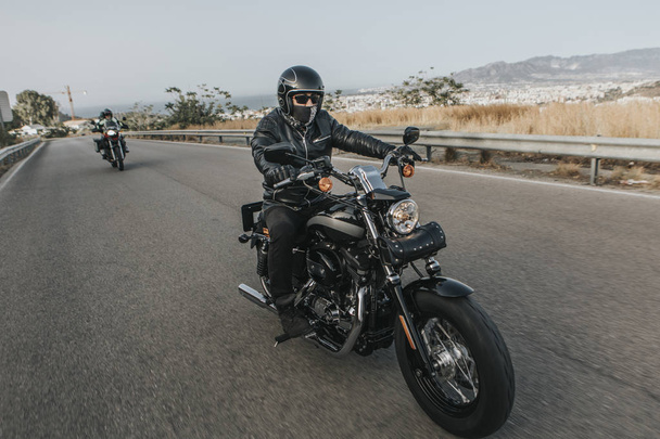 Man in black clothes riding a black classic american motorcycle  - Fotoğraf, Görsel