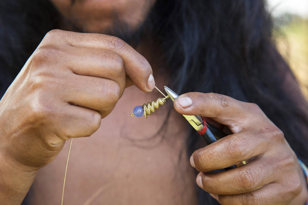 Jewelry maker hands creating earrings from brass metal string - Photo, Image
