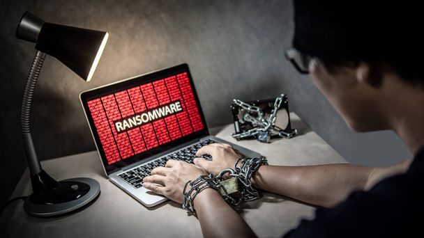 Pevném disku soubor uzamčen s monitorem Ukázat červený binární ransomware útočí na přenosném počítači. Uživatel ručně spoutáni řetězy a visací zámek. Kybernetický útok a Internet data bezpečnostní koncepce - Fotografie, Obrázek